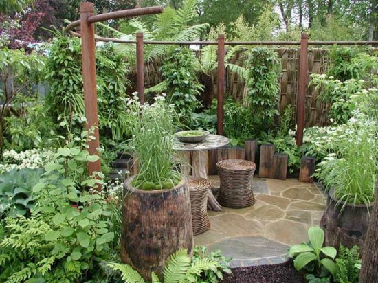 un jardin bien fleuri avec des plantes et des meubles rustiques