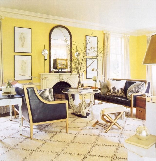 salon murs jaunes déco miroir fauteuil noir en cuir table basse salon canapé en cuir miroir tableaux déco