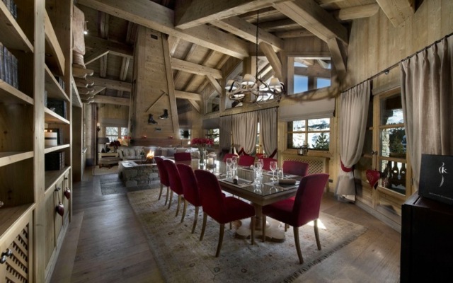 La salle à manger élégante en bois et à touches de bordeaux chalet Alpes Courchevel ski
