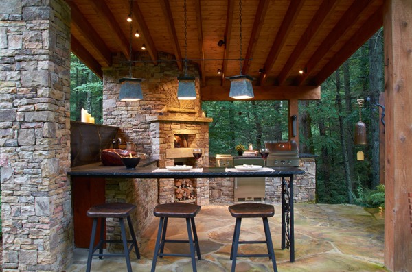 cuisine sous patio avec un bar et cheminee pierre