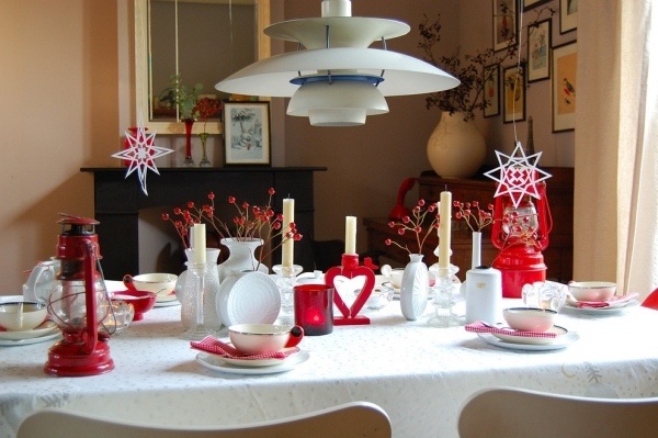 décoration-table-Noël-lanternes-rouges-bougies-blanches-nappe-blanche-branches-baies-rouges