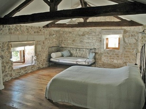 murs pierres sol bois vue grand lit