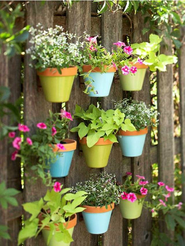 décorer jardin vases peints accrochés palissade