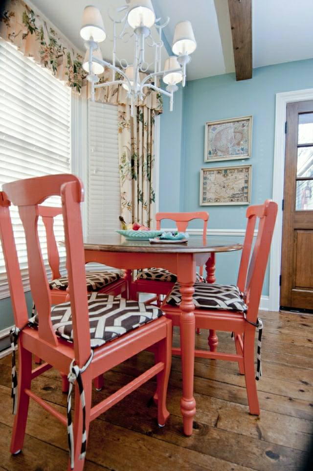 salle à manger table en bois couleur corail murs bleus lampe design