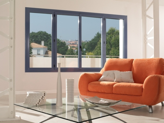 fenêtre en alu bleue canapé orange table de salon basse en verre 