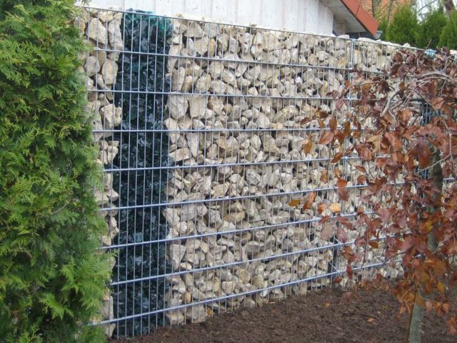 mur en pierre contenu dans une cage en fer