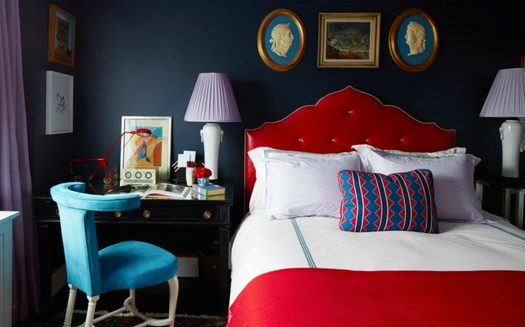 aménagement chambre à coucher lit tapisserie rouge blanche coussin à motif lampe fauteuil bleu décoration murale