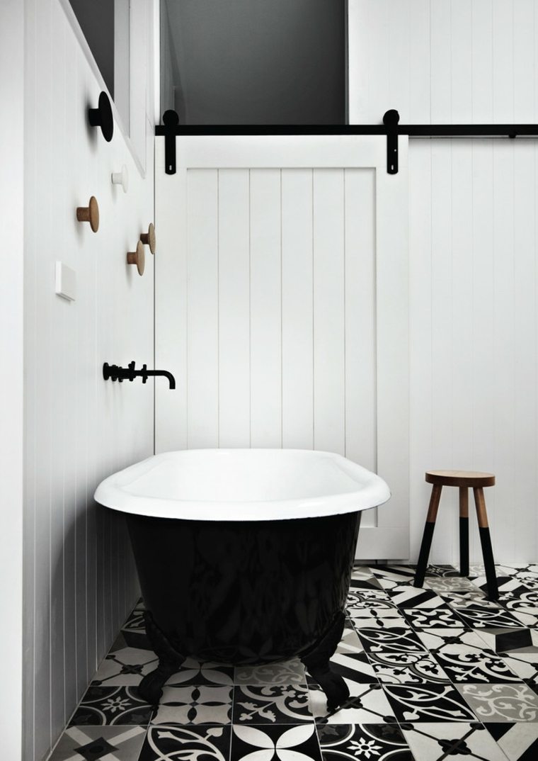 intérieur salle de bain moderne porte blanche coulissante baignoire noire blanche carrelage