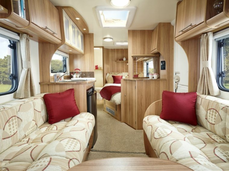 intérieur de caravane canapé coussins rouge aménagement cuisine bois