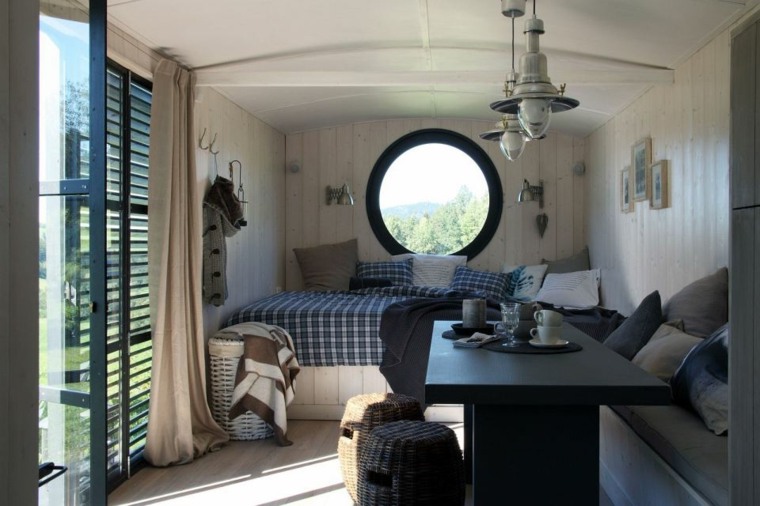 intérieur de caravane aménagement miroir rond rideaux table en bois noir design luminaire suspension