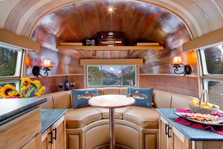 caravane intérieur idée aménagement coussins table ronde plafond bois 