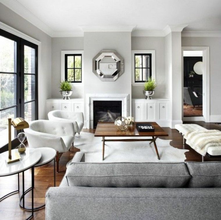 intérieur design moderne idée cheminées modernes canapé gris fauteuil blanc table en bois miroir mur 