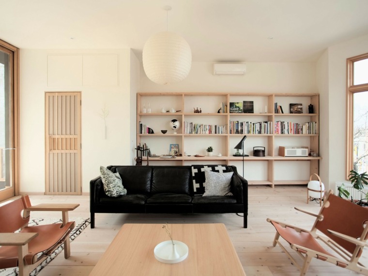 ambiance cosy intérieur salon canapé noir coussin bibliothèque bois table en bois basse 