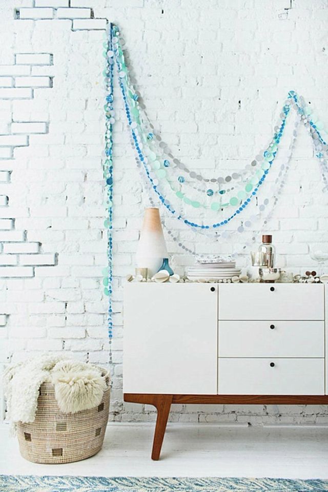 déco de fête idée mur décoration guirlande bleue mur briques meuble blanc bois