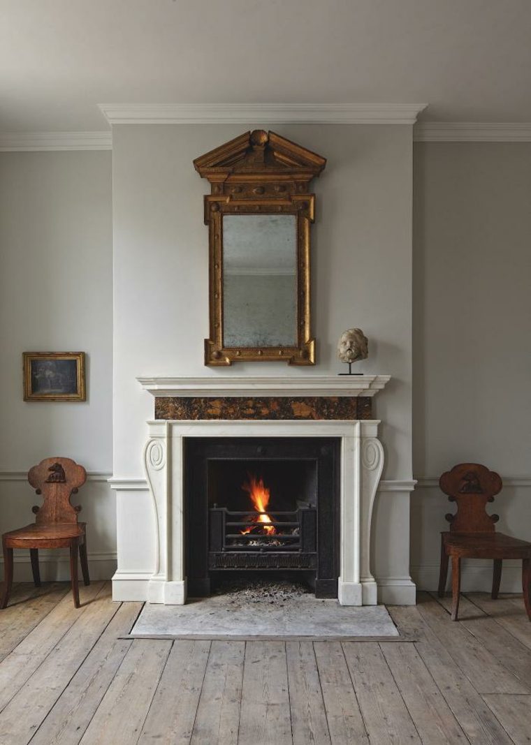 habillage cheminée classique design blanche moderne miroir idée tapis parquet en bois déco chaises 