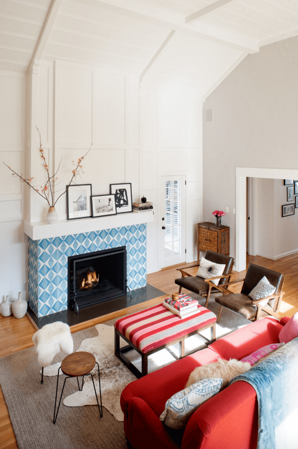 cheminée bleue déco cadre photo noir et blanc salon aménagement design fauteuil idée tabouret canapé rouge
