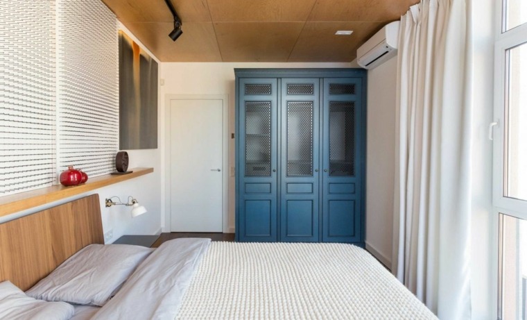 armoire design bleu bois chambre à coucher idée aménagement étagères en bois design coussins armoire bleue