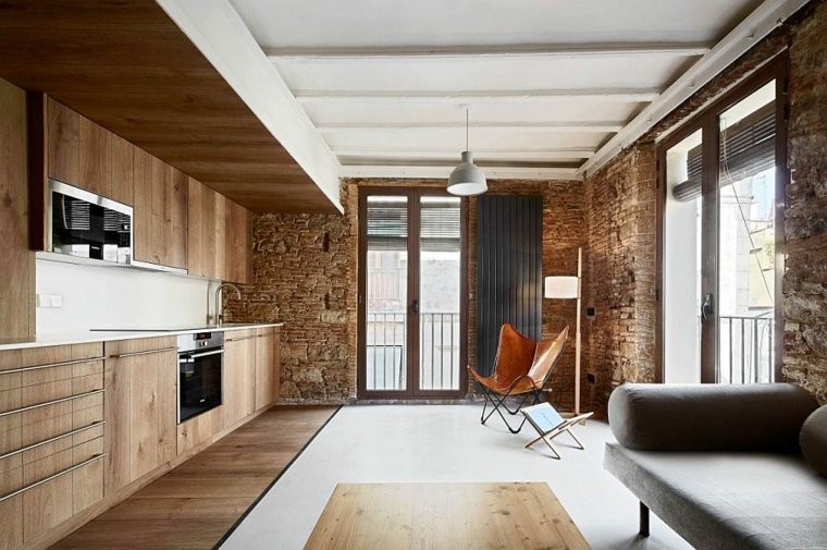 appartement de vacances cuisine bois mobilier salon canapé gris fauteuil cuir parquet bois mur briques