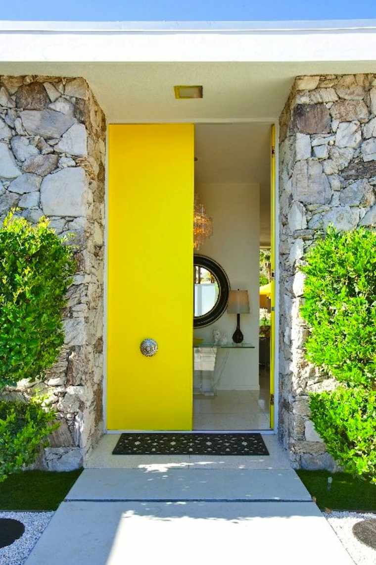 porte d'entrée en bois jaune vif idée aménager extérieur tendance mur pierres
