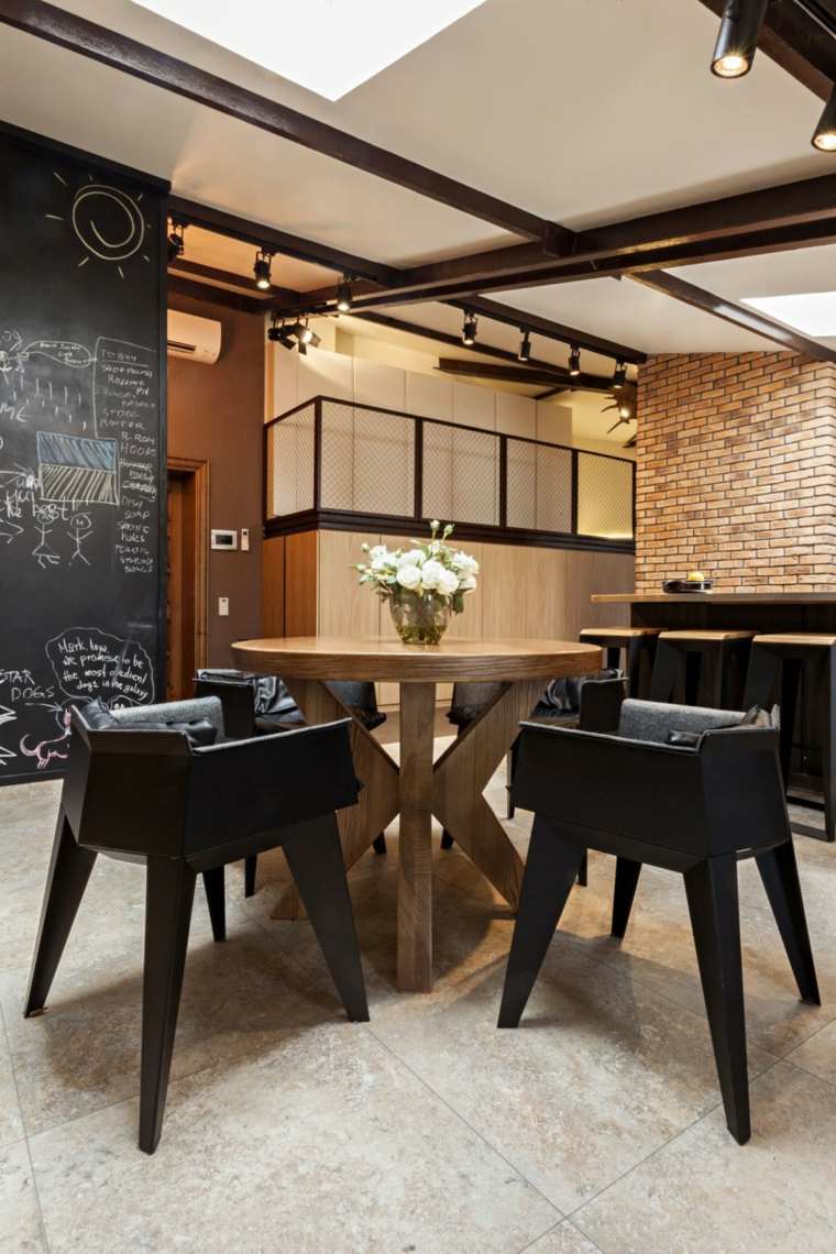 coin repas design espace ouvert salle à manger chaises noires design table ronde bois mur briques
