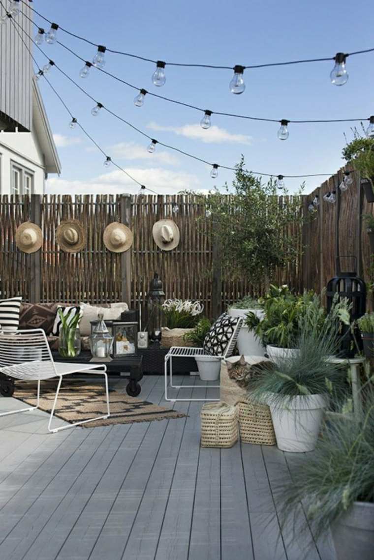terrasse toit idée fauteuil coussins guirlande lumineuse revêtement sol bois