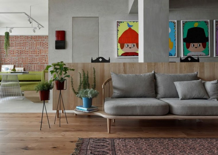 intérieur moderne design canapé gris coussins mur briques tapis sol cadres