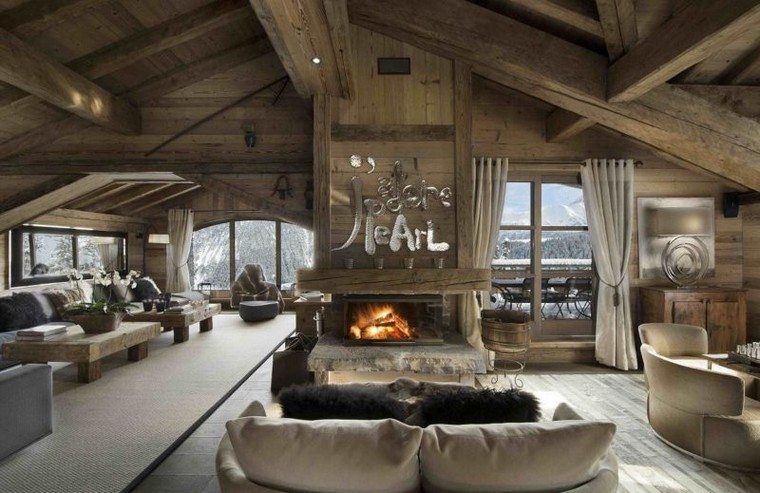 chalet montagne location plafond bois canapé coussins cheminée foyer central