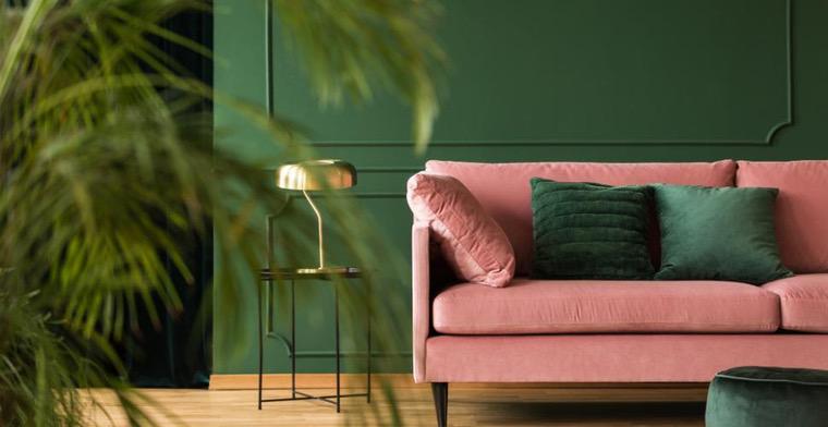 salon design avec mur vert et canapé rose