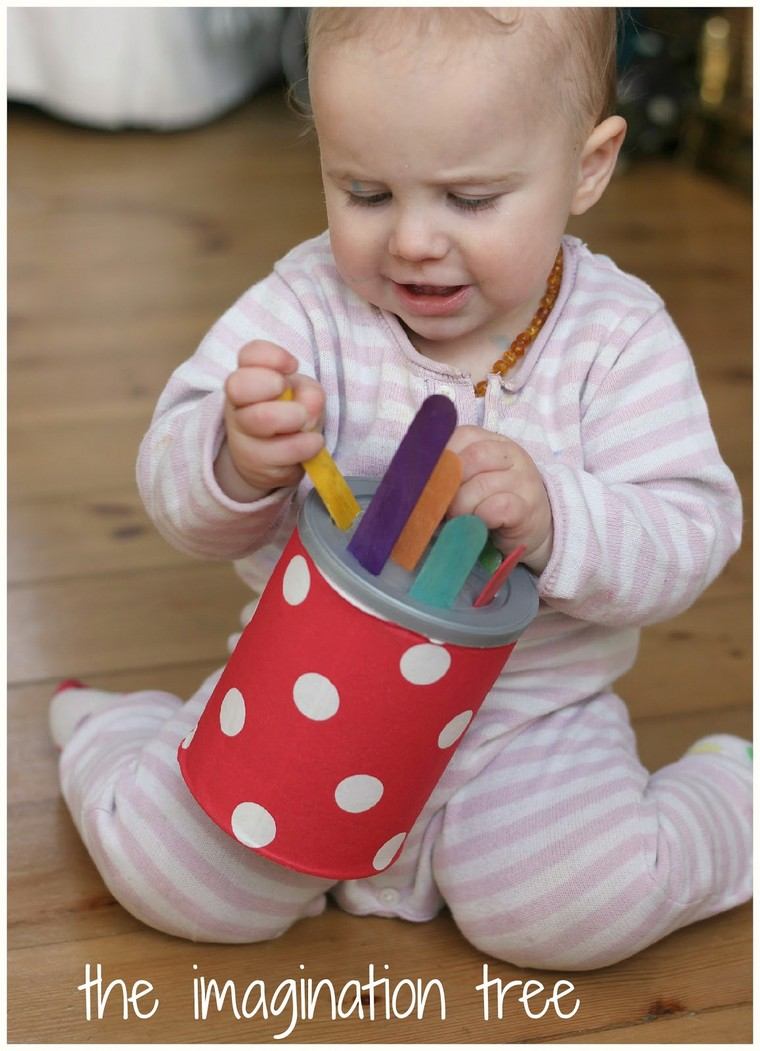 bébé jouant sticks boîte