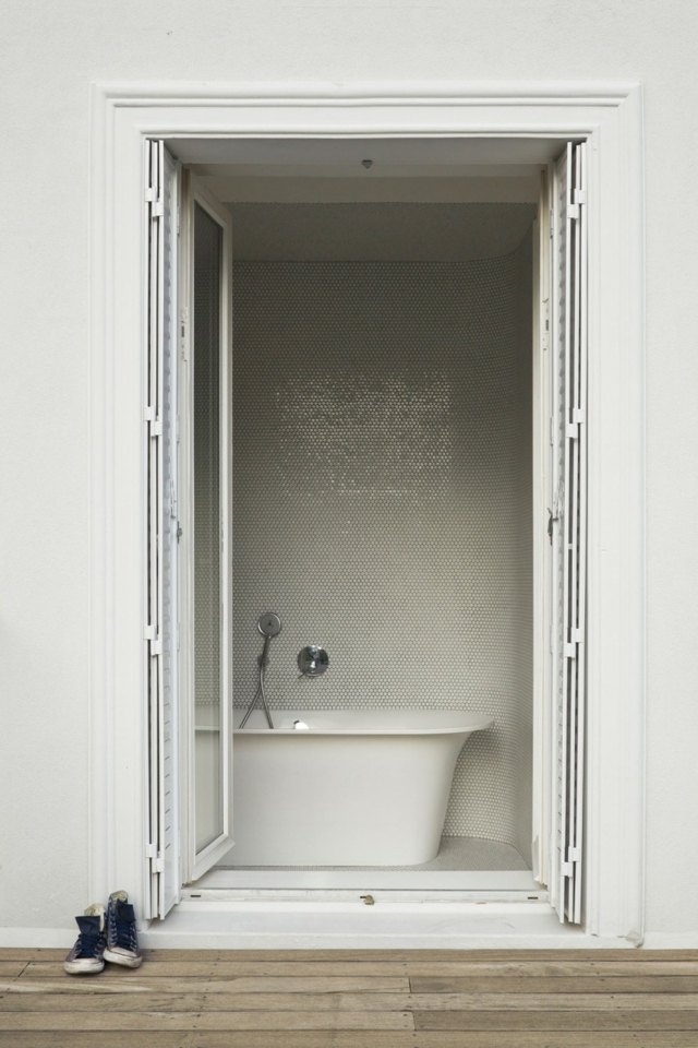 Le baignoire semble être caché dans une pièce séparée salle de bains gris