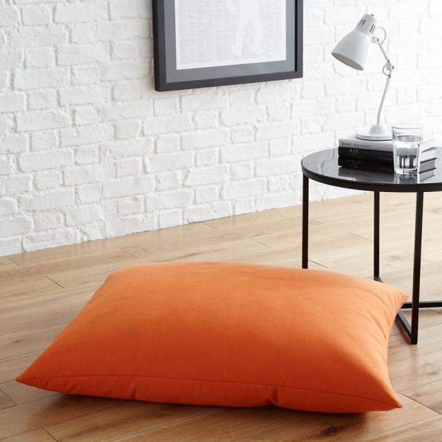 coussin de sol orange-table-noire-lampe-blanche