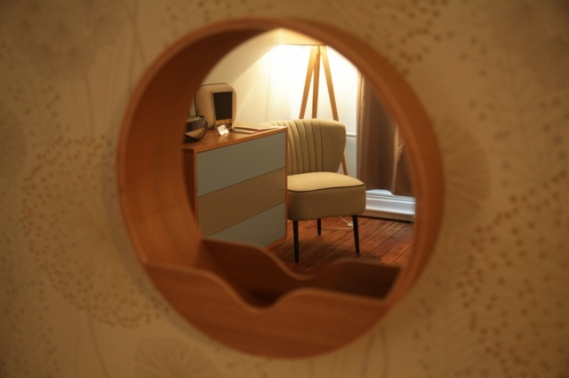Beau petit détailbaige bois miroir rond on voit une partie de la chambre d'hôte