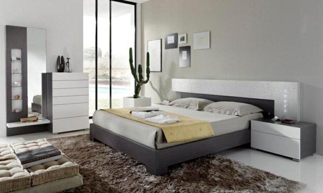 idées-déco-chambre-coucher-couleurs-naturelles-mur-gris-clairètpete-lit-blanc-gris-table-chevet-basse-tapis-marron idées déco chambre à coucher