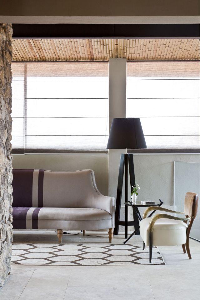 luminaire-salon-lampe-pied-noire-élégante-canapé-chaise-cuir-élégants-tapis-blanc-motifs-marron luminaire salon