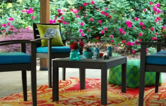 patio avec tapis colore fond buisson fleuri