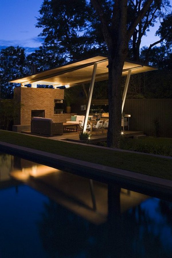 patio éclairé de nuit reflet piscine lac cadre boisé