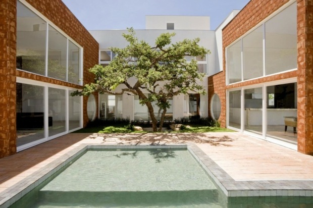 terrasse idyllique ponctuée d'une piscine et bel arbre